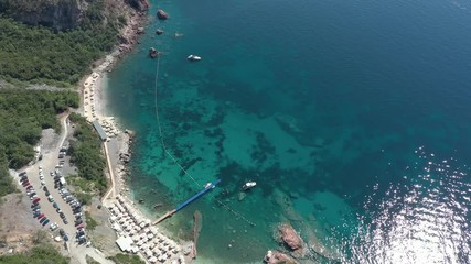 Drone flies above the coastline of the Adriatic sea, southern Montenegro, in a sunny summer day. Water in the sea is turquoise, clean and clear