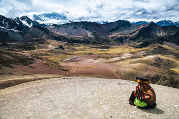 Woman sitting at Rainbow Mountain hike in the Peruvian Andes near Cusco, Peru