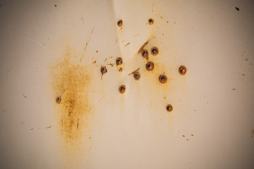 bullet holes in white rusty metal, background