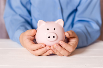 A man holds a piggy bank in his hands. Family savings.