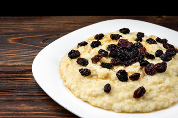 Millet porridge on dark wooden background.