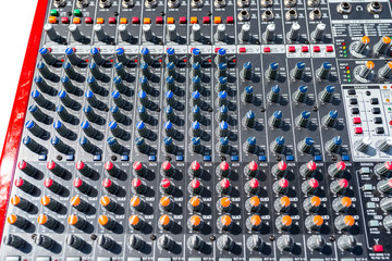 Close up photo of a professional sound mixer with many adjustments, knob switches and buttons of...
