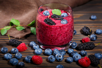 Glass of smoothies and a bunch of fresh berries