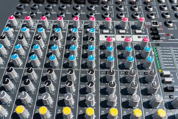 Fototapeta premium Close up photo of a professional sound mixer with many adjustments, knob switches and buttons of audio mixer control panel.