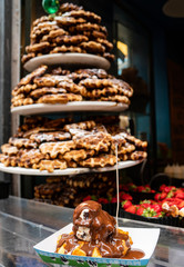 delicous waffle with ice cream and chocolate sauce with a colourful foody background