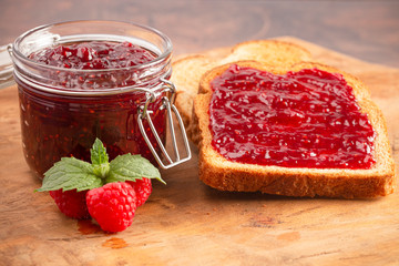Jar of Raspberry Jam on a Rustic Wooden Table
