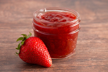 Jar of Classic Strawberry Jam on a Rustic Wooden Table