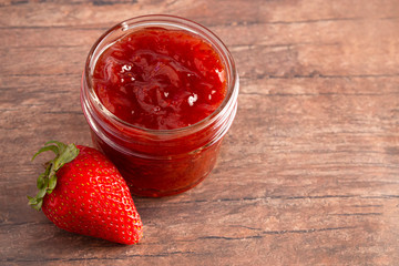Jar of Classic Strawberry Jam on a Rustic Wooden Table