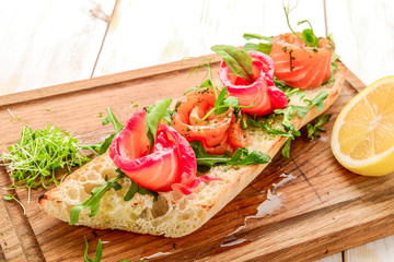 Fototapeta na wymiar Sandwich with toasted bread and salmon on a wooden table