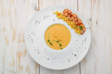 Creamy oil and spices soup, is served with shrimps