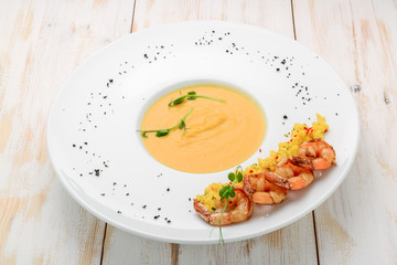 Creamy oil and spices soup, is served with shrimps
