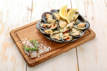 Delicious seafood mussels with with sauce and parsley. Lemon and baguette . Clams in the shells. Top view.