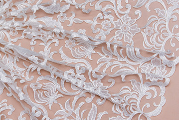 Texture lace fabric. lace on white background studio. thin fabric made of yarn or thread. a background image of ivory-colored lace cloth. White lace on beige background.