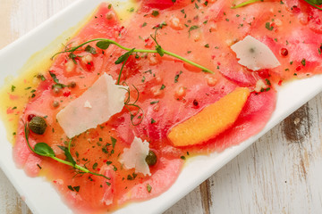 Restaurant Starter Menu with Slightly Salted Salmon Fillet Isolated on White Background. Thin Slices of Red Fish or Trout with Lemon and Greens o