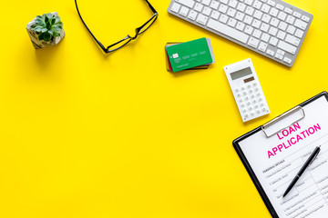 loan application with bank cards and keyboard on yellow background top view space for text