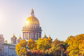 View of St. Isaac's Cathedral with a brilliant golden dome autumn trees of the Alexander Park St....