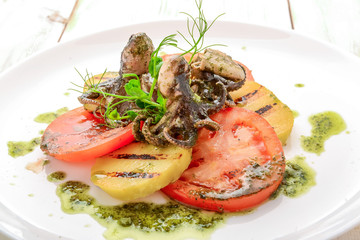 Grilled octopus on a plate.,grilled octopus with grilled vegetables