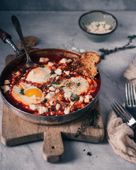 Spiced tomato Shakshouka in cast iron skillet. African cuisine breakfast