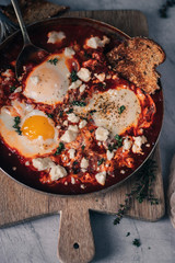 Spiced tomato Shakshouka in cast iron skillet. African cuisine breakfast