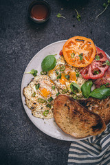 Spicy Turkish fried eggs for breakfast with fresh ingredients, tomatoes, yogurt and naan bread. 