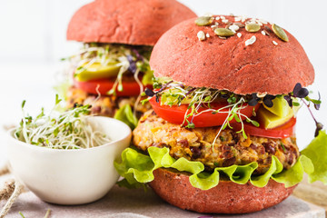 Pink vegan burgers with beans cutlet, avocado and sprouts on white background.