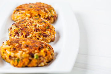 Vegan bean rice burgers cutlets on white dish.