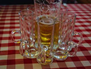 Hungarian palinka alcohol shot glass kept in a pattern around a beer glass during the gathering of friends outdoor