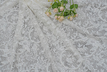 The texture of lace on wooden background decoreted roses.