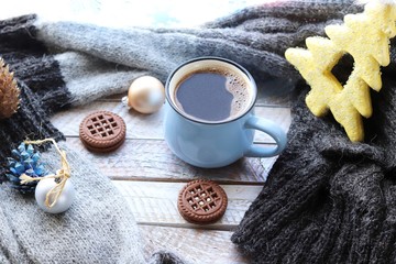 Cup of coffee, Christmas decor, spruce branch, balls, woolen plaid on the window background, home comfort concept, seasonal winter celebrations
