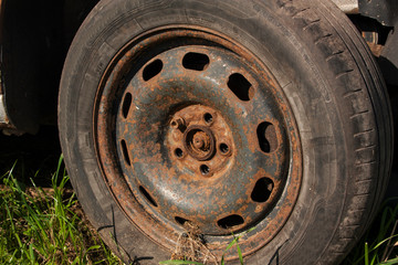 old rusty stamped steel wheel on a machine with 1 bolt