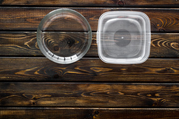 Empty bowl and food container on wooden background top view