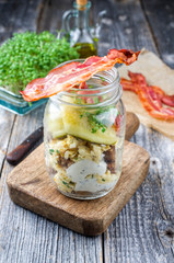 Brotzeit im Glas – traditionelles bayrischer Snack mit Speck, Eier und Schwarzbrot in einem Glas...
