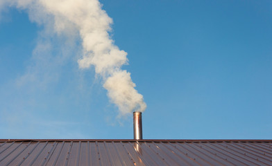 Smoke coming out the chimney against sky