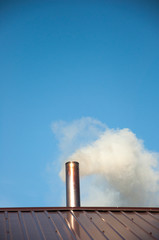 Smoke coming out the chimney against sky