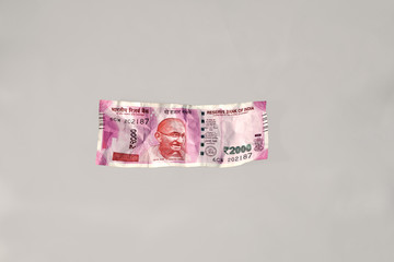 wrinkled modern Indian Two Thousand Rupees Currency Note on a minimal grey background