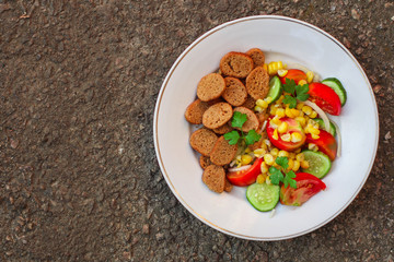 salad vegetables and croutons (tomato, cucumber, onion, cracker, corn and other ingredients) menu. top food background. copy space