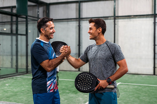 two padel players shaking hands after win a padel match