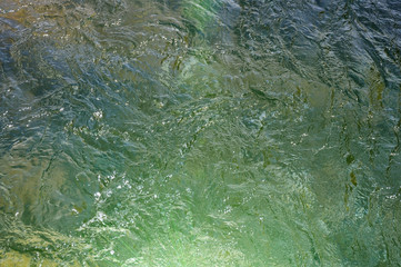 Water of a fast mountain river with rapids.