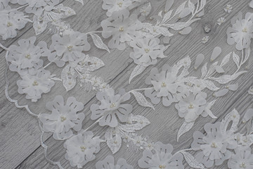 White wooden background with white spring flowers roses and lace ribbon. Happy womans day. The...