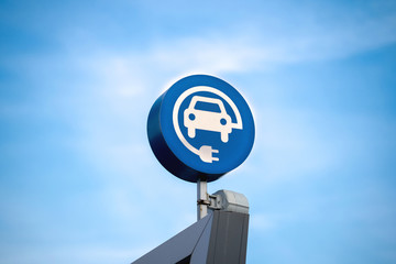 electric vehicle charging sign, blue sky background