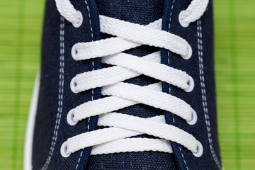 Close-up shot of new blue gumshoe with white shoelace