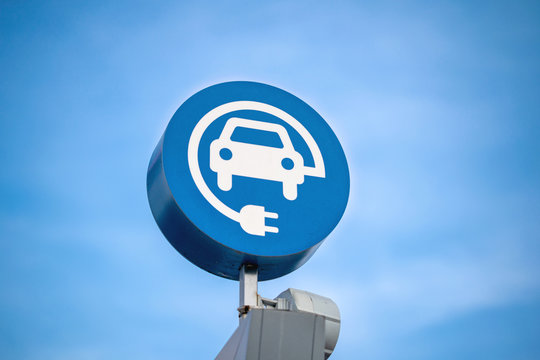 electric vehicle charging sign, blue sky background