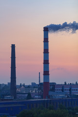 Shot of exhaust pipes and factory buildings in the early morning