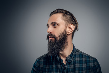 Attractive tired man at photo studio is posing for photographer on the light background.