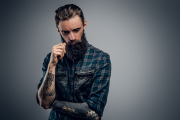 Bearded skinny man with tattooes feels dispair and sorrow while thinking about life.