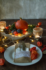 Thanksgiving dinner. Halloween dinner. Festive table with chicken and all side dishes, pumpkin, autumn leaves and seasonal autumn decor. The table is decorated with a garland, top view.