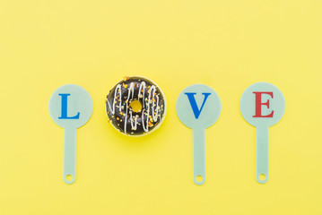 donuts on a yellow background and space for text. Word love.