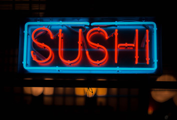 neon sushi sign outside of a restaurant