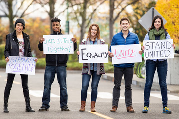 Group of five people protesting outside with signs