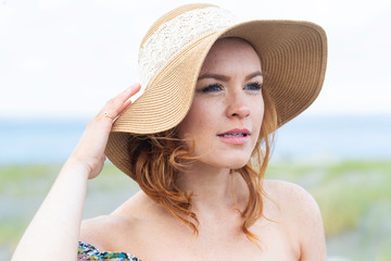 Beautiful woman with red hair at the beach